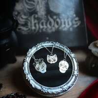 Les Calaveras sacrés 💀
Notre route se poursuit et nous mène maintenant au coeur du Mexique 🏵️ 
En cette période sacré de El Día de los Muertos, l’air semble vibrer de couleurs et de mystères 💀 
Ici, la mort n’est pas un long silence, mais une danse. Les rues se couvrent de fleurs éclatantes, de bougies, de fêtes et de moments partagés avec les ancêtres ✨ 
Chaque année, en cette période si spéciale, les familles dressent des autels, les ofrendas, pour accueillir le retour de leurs ancêtres, leurs montrer le chemin jusqu'à la maison 💀 
On y dépose des fleurs, bougies, encens, photos, mets préférés en offrande à nos défunts et des calaveras 🕯️Sur chaque autel, ils apparaissent. Des crânes sculptés dans le sucre, la céramique ou le bois, parés de mille couleurs 🏵️ 
Les calaveras sont un rappel que la mort n’est pas une fin, mais un retour. Ils honorent les esprits et leur ouvrent la voie vers la maison. Leur sourire coloré est un signe de bienvenue, une invitation à partager un instant de fête et de mémoire avec les vivants ✨ 
Ils ne sont pas des symboles macabres, mais des messagers de joie, rappelant que la vie et la mort s’entrelacent dans un même cercle 🏵️ 
Les calaveras portent en eux une mémoire ancienne, ils honorent ceux qui sont partis, tout en nous rappelant que chaque instant de vie est précieux. Ils transforment l’ombre en lumière, le deuil en célébration, et nous invitent à marcher aux côtés de nos morts comme de nos vivants, le cœur toujours ouvert 🕯️🧡💀 
Alors pour honorer ceux qui sont partis trop tôt, j'ai créé pour vous trois petits médaillons talismans en argent massif 925 ✨ 
Des pendentifs calaveras, pour honorer femmes, hommes et animaux chers à nos coeurs, qui ont disparus, mais qu'on garde toujours contre notre coeur 🧡 
Dans chacun de leurs yeux, des pierres pour les parés de mille couleurs. Des améthystes violettes pour les femmes, des tourmalines vertes pour les hommes et de jolies tourmalines jaunes pour les animaux ✨ 
J'espère qu'ils vous plairont autant qu'à moi 🙏 
Pièces uniques, disponibles le lundi 13 octobre à 20h pour la nouvelle collection ~ La route des Sorcières ~ 🧙♀️🐈⬛✨