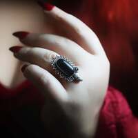 Santa Muerte - La Reine des Ombres 💀
Une nouvelle figure sacrée se présente à nous ce soir, la Santa Muerte, la Sainte du peuple 🖤
Pour beaucoup elle fut longtemps une figure redoutée, au Mexique elle est aujourd’hui vénérée comme une mère universelle, protectrice, qui accueille sans jugement. Une souveraine de la mort, vêtue de longs voiles noirs et coiffée d’une couronne précieuse ✨
Si elle peut effrayer par son apparence, son rôle est d’abord protecteur. Elle écoute les dévots, soutient les oubliés, protège les voyageurs, les marginaux, les âmes en quête de justice. Sa faux n’est pas menace mais délivrance, elle coupe les liens nocifs, éloigne les dangers et trace un chemin clair 💀
La Santa Muerte n’exclut personne, elle protège sans condition. Elle n’abandonne personne, elle accompagne toutes les âmes et veille à ce que chaque promesse soit tenue. Elle est un refuge pour les marginalisés, particulièrement vénérée par ceux qui se sentent rejetés ou invisibles dans cette société.
À ses pieds et dans ses bras, on dépose des roses. Symbole de l’amour, du dévouement et du lien indestructible entre elle et les vivants 🌹
Sa symbolique est puissante, la Santa Muerte incarne la vérité ultime.💀 Celle que la mort touche chaque être de la même façon, sans différences, sans hiérarchies. Elle est l’égalité, la justice et la certitude que rien ni personne n’échappe à son regard ⚖️
Mais elle ne se réduit pas seulement à l’idée de fin. Elle protège, elle écoute, elle soutient, elle accompagne la vie. On l’invoque pour traverser les épreuves, pour être guidé et trouver la force dans les moments difficiles.
Elle veille sur les chemins incertains, guide les pas perdus et éloigne les dangers invisibles. Elle marche auprès de chacun d'entre nous, surtout quand la nuit semble un peu trop longue.. 🖤
En l'honneur de la Santa Muerte, ce soir c'est une bague unique que je vous présente. En argent massif 925 et entièrement faite main à l'atelier.
Pour garder toujours sa protection près de vous 💀
Une pierre d'obsidienne noire comme son voile, ornée de sa couronne précieuse, d'un crâne et de quelques roses en offrande🌹
Disponible lundi prochain à 20h 🧙🏻♀️