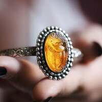 L'Or du Temps 🍯 

On dit que le miel d'été est l'un des plus précieux 🐝 
Car il porte en lui l'apogée de la saison lumineuse 🌞 

Depuis l'Antiquité, le miel est considéré comme un aliment sacré. Symbole d'abondance, de prospérité et de douceur, il est offert aux dieux, utilisé dans les rituels et associé à l'immortalité dans de nombreuses traditions. On lui prête le pouvoir d'apporter force, guérison et protection 🍯 

Les abeilles, elles aussi, occupent une place toute particulière. Messagères entre les mondes, porteuses de sagesse, d'harmonie et de bénédiction. Mère du monde, sans elles, la vie telle que nous la connaissons n'existerait pas 🐝 

Elles nous rappellent que les plus belles récoltes sont souvent faites de patience. Le miel d'été en est le fruit 🍯 

Il ne naît ni dans la précipitation, ni dans l'abondance soudaine. Il est le résultat de milliers de voyages, de journées de travail silencieuses, de fleurs visitées une à une sous la lumière puissante du soleil ☀️

Récolté au cœur de l'été, lorsque la nature atteint son apogée, il devient le symbole de ce qui a mûri avec le temps, de ce qui a été nourri, protégé et cultivé avec soin 💛 

Comme les abeilles, nous passons nos saisons à bâtir, à avancer, à semer, à traverser les tempêtes et les saisons. Mais jour après jour, nous récoltons bien plus que nous ne le croyons 🍯
Pourtant, nous oublions souvent de goûter à la douceur de ce qui est déjà là. Nous regardons ce qui manque encore, sans voir les récoltes que nos efforts ont déjà patiemment façonné. 

Ce bracelet est un rappel. 
Celui de s'arrêter un instant. 
De regarder le chemin parcouru et de savourer le miel de vos jours lumineux  💛 

C'est est un bracelet unique. Un jonc en argent massif 925 en taille ajustable. 

Il protège une incroyable ambre dans laquelle est sculptée une délicate abeille 🐝🍯

Et en son cœur, comme une secret bien gardé rien qu'à vous, j'y ai gravé ces mots " Savoure le miel des jours lumineux " pour ne jamais oublier de prendre le temps de profiter de ce qui est déjà là 💛 

C'est une pièce unique, disponible le lundi 20 juillet à 20h pour la nouvelle collection ~ Un Été Sacré ~ ☀️🌾🔥 

#cybijoux #été #abeille