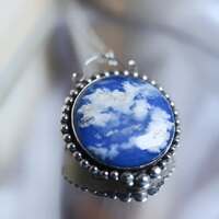 Les promesses d'infini 💙
Le ciel bleu, lui, est une promesse précieuse d'infini, posé au-dessus de nos doutes. Un abri sur le monde, un horizon des possibles 🌍
Il veille en silence, immense et patient ☁️
Il nous rappelle la légèreté qu'on a parfois oubliée, la liberté unique offerte par les oiseaux qui le parcourent, la vastitude de nos rêves en son coeur que rien ne limite. Il nous enseigne que la hauteur n’est pas toujours une question d’ailes, mais d’audace ! 🪽
Le bleu c'est la couleur des âmes légères, celle des cœurs qui voyagent haut 💙
Mais le ciel ne se penche jamais sur ceux qui baissent les yeux.. Alors levez la tête, osez l'immense, rêvez d'horizon infini ✨
Car l’infini commence précisément au moment où l’on décide de croire que tout devient possible 💙
Ce soir ce sont deux médaillons que je vous présente, en argent massif 925 et toujours entièrement fait main à l'atelier ✨
Ils protègent eux aussi d'incroyables pierres d'agate plume doublet dans lesquelles se dessinent un merveilleux ciel bleu et ses nuages 💙
J'ai gravé au revers des médaillons, ces mots précieux rien que pour vous " L'horizon des possibles " & " Oser l'immense " pour que vous n'oubliez jamais de rêver aussi grand que votre ciel ☁️
Disponibles lundi 23 mars à 20h pour la sortie de la nouvelle collection Les Couleurs du Ciel ~ 🌅☁️✨
#cybijoux #jewelry #skylover #skyjewelry #sun