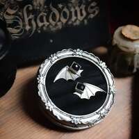 Noaptea Strigoilor - La Nuit des Esprits ✨ 

Lorsque novembre touche à sa fin, la Roumanie entière retient son souffle.. C'est la nuit la plus redoutée de toute, la Noaptea Strigoilor, la Nuit des Esprits 🌑 

On dit qu’en cette veille de la Saint-André, les strigoï, âmes errantes, monstres, vampires et ancêtres mécontents, quittent leurs antres pour revenir parmi les vivants 🧛🏼‍♂️ 

Dans les légendes roumaines, on murmure même que les strigoï, peuvent se métamorphoser en chauve-souris, celle qui traverse les mondes sans jamais s’y perdre, pour regagner la nuit après leur passage sur terre. 

Une créature du seuil, une messagère des profondeurs, un guide des âmes à travers la nuit 🦇 

Cette nuit suspendue entre deux mondes nous rappelle que la frontière entre la vie et la mort, entre le réel et le magique, ne tient finalement qu'à un battement d'aile.. 

Dans le silence hivernal des Carpates,
La Noaptea Strigoilor est un miroir tendu à nos ombres, nos propres ténèbres, non pour nous effrayer, mais pour nous rappeler que la lumière ne peut exister sans elles 🌗 

En l'honneur de cette nuit si spéciale, ce soir c'est une paire de boucles d'oreilles que je vous présente. En argent massif 925 et toujours entièrement réalisées main à l'atelier ✨ 

Des clous d'oreilles délicats en onyx noire  comme la nuit, taillée à facettes pour faire ressortir le précieux.  Et des ailes de chauve-souris qui viennent s'attacher par l'arrière de votre oreille pour l'épouser parfaitement 🦇 

Douces et légères à porter 🖤 

Placées à vos oreilles pour voir tout ce qui vous entoure, elles seront de fidèles alliées et conseillères pour traverser la saison sombre 🦇 

Pièce unique, disponibles lundi prochain, le 13 octobre à 20h pour la nouvelle collection ~ La route des Sorcières ~ 🧙‍♀️🐈‍⬛✨ 

#cybijoux #creatricefrancaise #witch #witchjewelry #metalsmith #jewellery #sterlingjewelry #witchcraft #artist #witchyvibes #jeweler #jewel #jewellerydesign #bat #roumanie
#autumn #vampire #pumpkin #magic #autumniscoming #pumpkinseason #halloween #spooky #samhain #fall #pumpkins #spookyseason #autumnleaves #esoteric