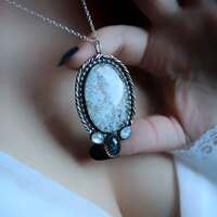 La Poésie du Froid ❄️
Et puis, comme si le ciel se souvenait soudain de sa douceur, la neige s'est mise à tomber.. 🌨️
Elle glisse entre les mondes, elle adoucit les contours, et c'est dans son silence que quelque chose en nous se répare.
La poésie du froid se glisse dans les plis du silence, dans la douceur d'un monde endormi par l'hiver. Elle se glisse dans les gestes lents, dans les souffles qui tremblent un peu, dans le cœur qui se resserre pour mieux protéger ce feu précieux qui brûle encore, avant de le laisser s'embraser à nouveau au printemps 🔥
La poésie du froid se glisse dans le bleu des matins d’hiver, dans les chemins effacés par la neige, dans les dessins du givre laissés sur les vitres comme des secrets confiés à la lumière ❄️
La poésie du froid, c'est comprendre que l'hiver n’est pas une fin, qu'il est un refuge, une respiration profonde, une trêve, un appel à revenir à l'essentiel, à prendre le temps..
Alors prenez le temps vous aussi, respirez, trouvez du sens et dansez au milieu du froid. Puis relevez les yeux, il finira toujours par revenir le beau temps.. 💙
C'est un médaillon unique que je vous présente aujourd'hui. En argent massif et entièrement réalisé main à l'atelier.
Il protège une pierre incroyable d'hemimorphite d'une qualité rare, pure, dans laquelle on peut voir la neige tomber délicatement ❄️
Une caynite au bleu profond et deux peristerites au blanc lumineux et aux reflets de magie l'accompagnent ✨
Dans son dos, à la lumière un joli flocon se dessinera en transparence ❄️
Un fragment de froid, immortalisé rien que pour vous, pour toujours garder la magie de l'hiver à vos côtés 💙
Pièce unique disponible demain, le lundi 8 décembre à 20h pour la sortie de la nouvelle collection ~ La Poésie du Froid ~ 🤍🌬️❄️
#cybijoux #hiver #witch #metalsmith #jewellery #sterlingjewelry #winterwitch #artist #witchyvibes #jeweler #jewelry #christmasaesthetic #jewellerydesign #bijouxfaitmain
#silverjewelry #artisanat #faitmain
#artisandefrance #winteraesthetic #hiver #christmasgiftideas #winter #neige #noelaesthetic #ideecadeau #christmas #snow
#cadeaufaitmain #noel2025 #yule